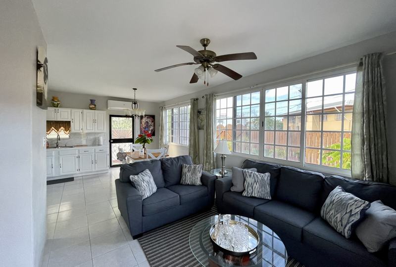 Bright living room at Central City Haven with sofa and ceiling fan